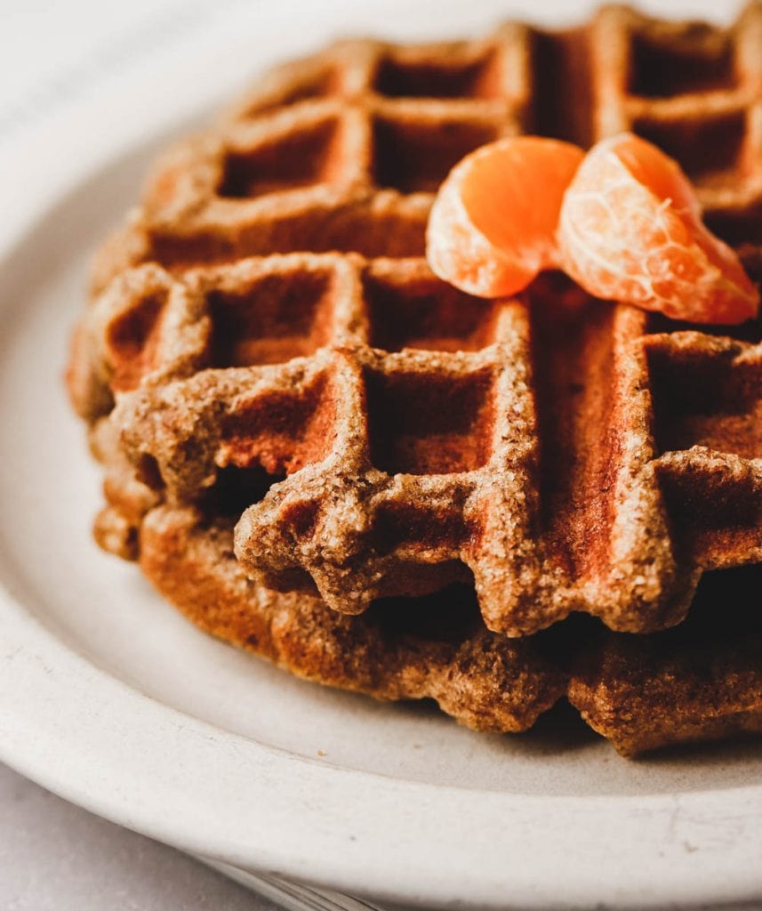 close up picture of waffles with oranges on top