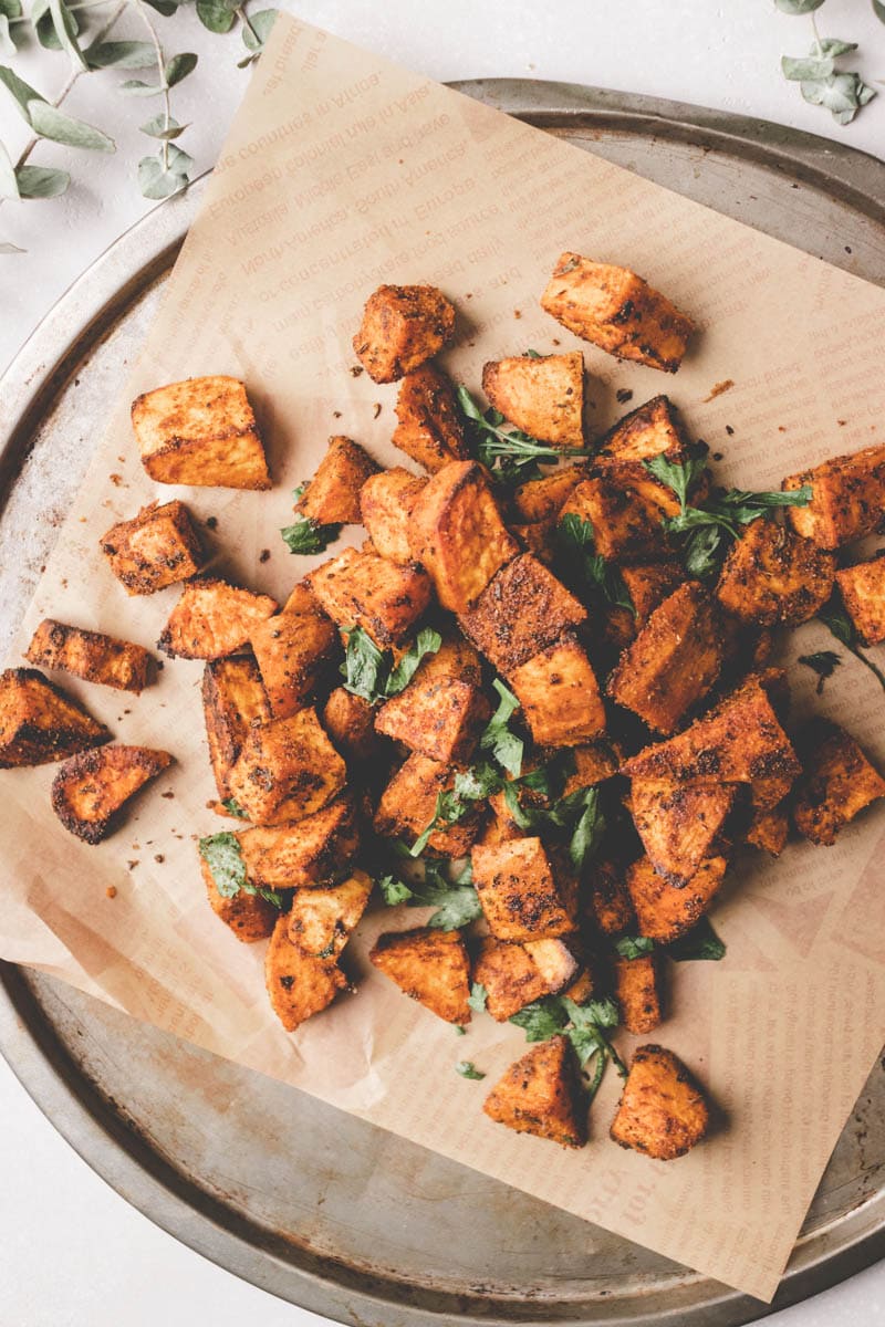 roasted sweet potatoes on a baking sheet with parchment paper