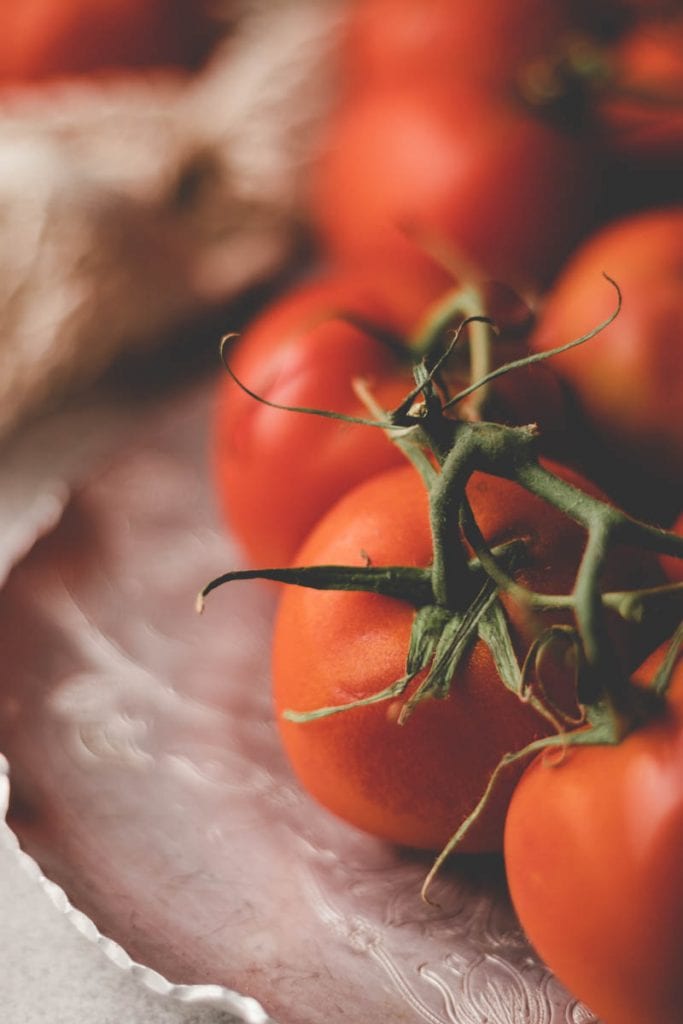 Basic Food Photography - picture of tomatoes on the vine on a vintage plate