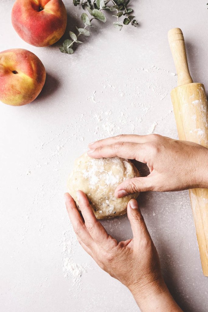 hands getting ready to roll out pie dough