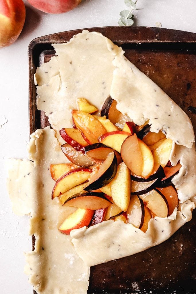 peaches and plums inside the crust of the galette