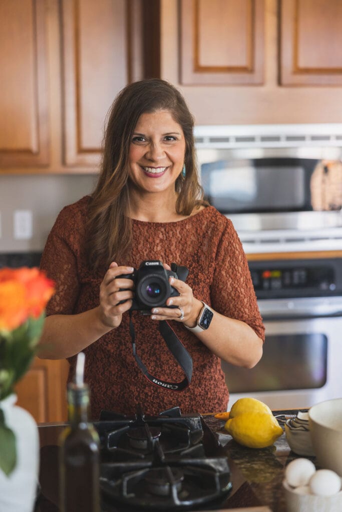 woman holding camera, smiling