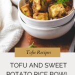 A white bowl filled with tofu cubes and sweet potatoes is garnished with parsley, resting on a wooden board beside another bowl. Text overlay reads: Tofu Sweet Potato Bowl.