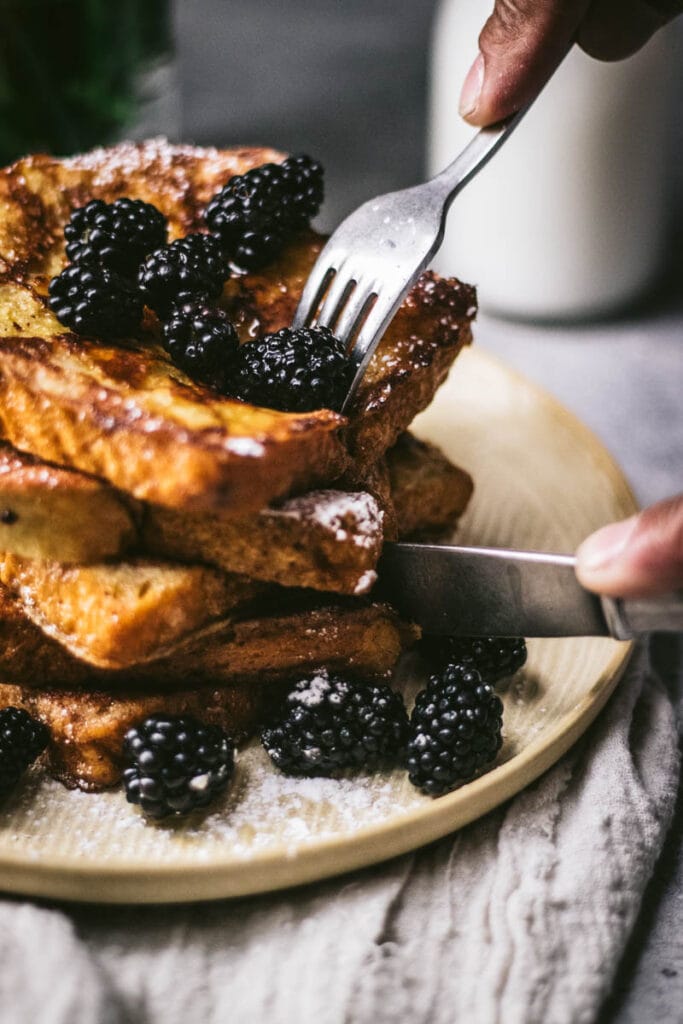 cutting into a french toast stack