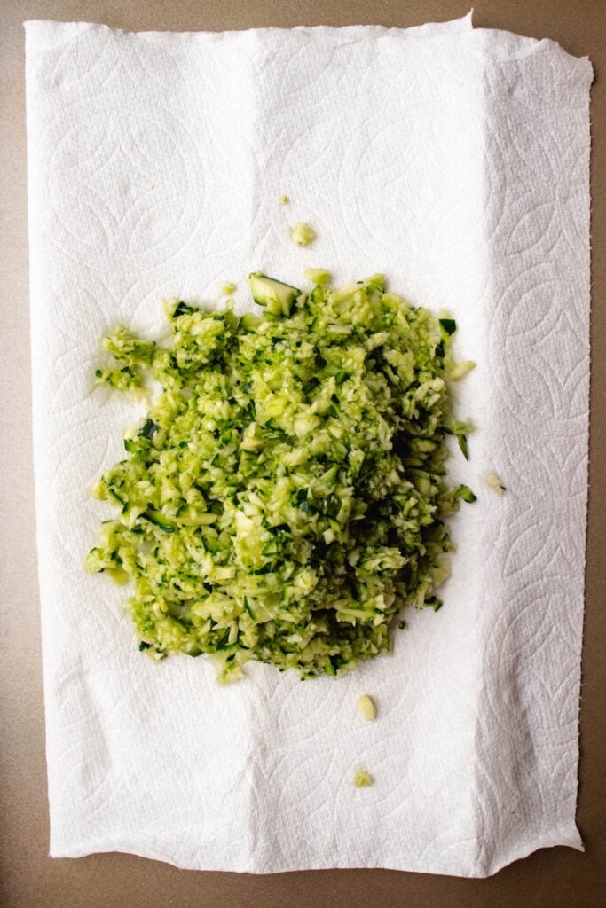 shredded zucchini on a paper towel