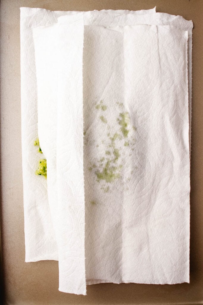 patting excess moisture from zucchini