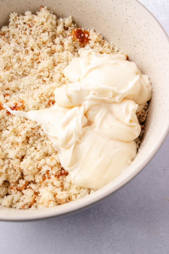 crumbled cake in a in a bowl with the frosting