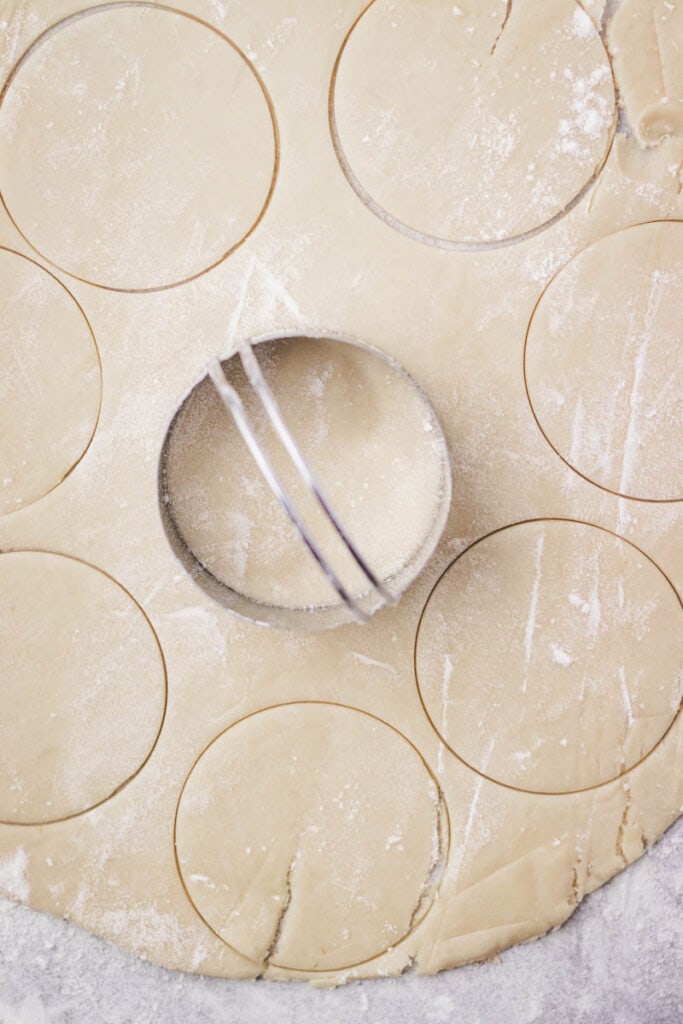 cutting the dough circles with a biscuit cutter