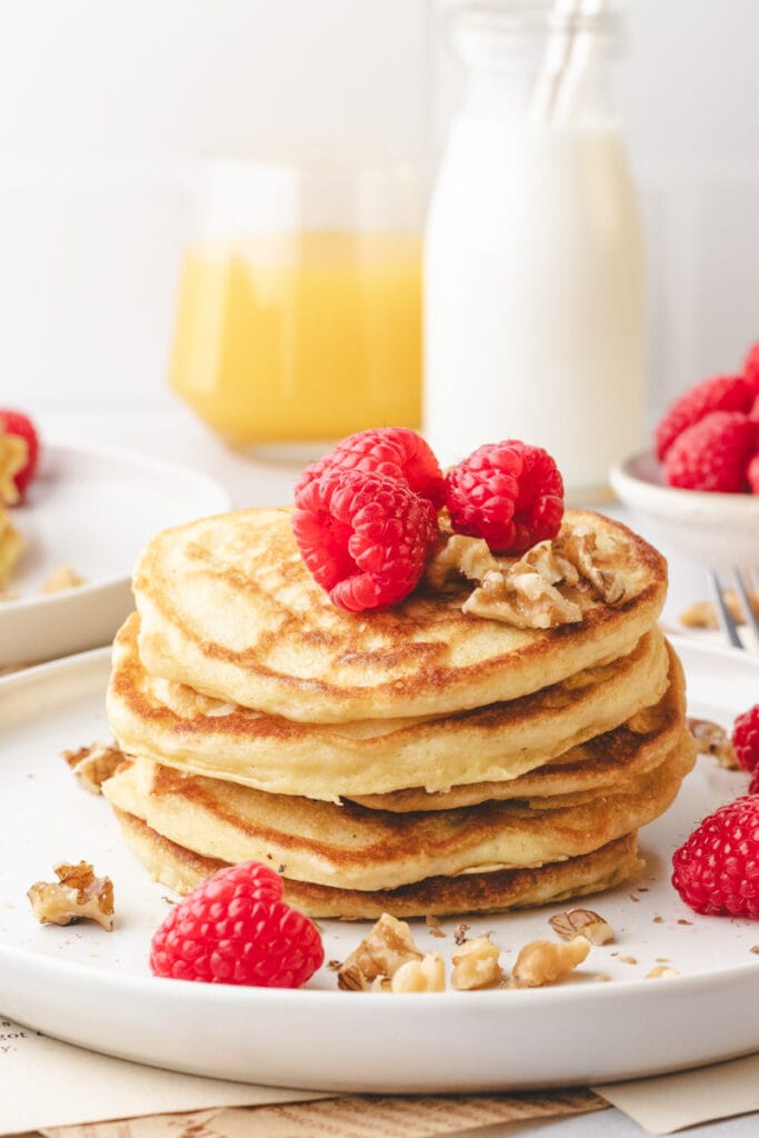stack of pancakes with raspberries on top.