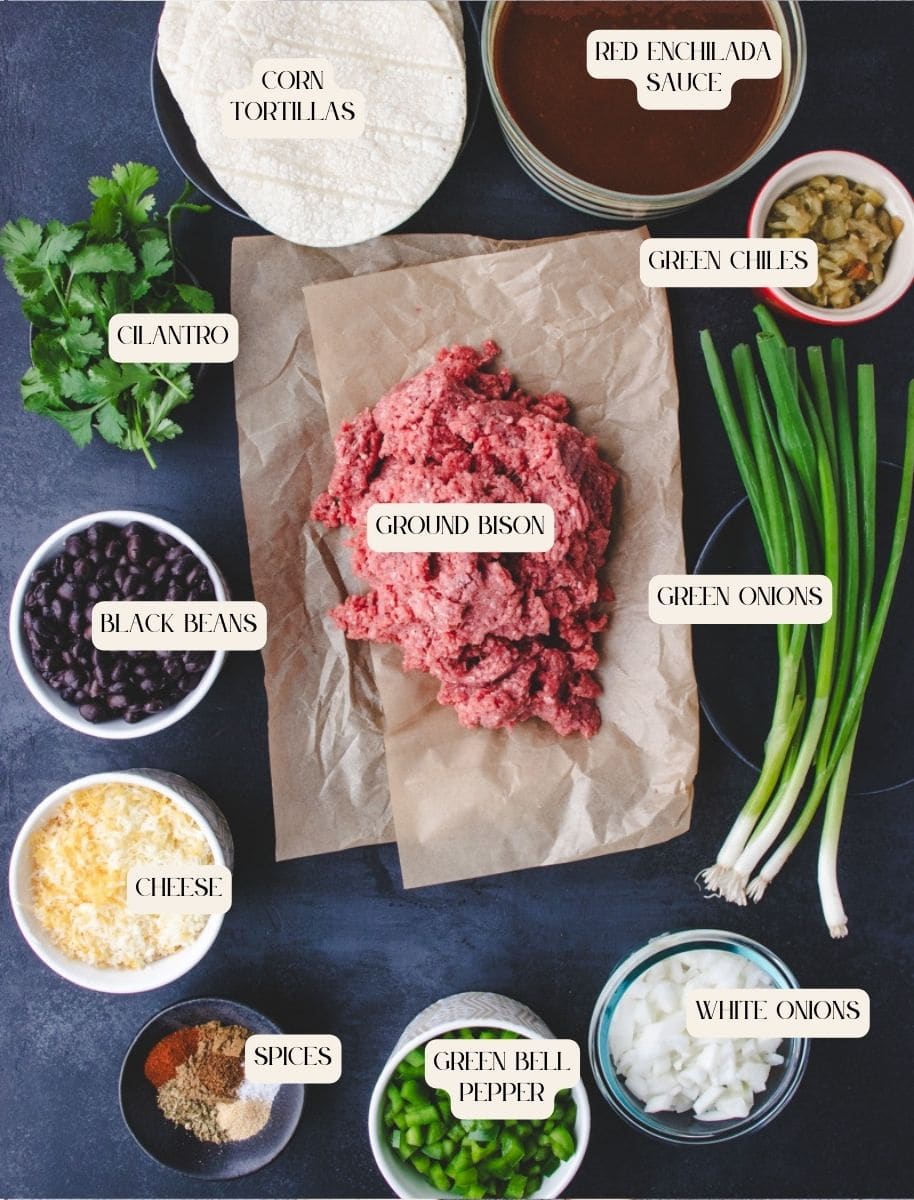 ingredients for bison enchiladas laid out on a dark surface.