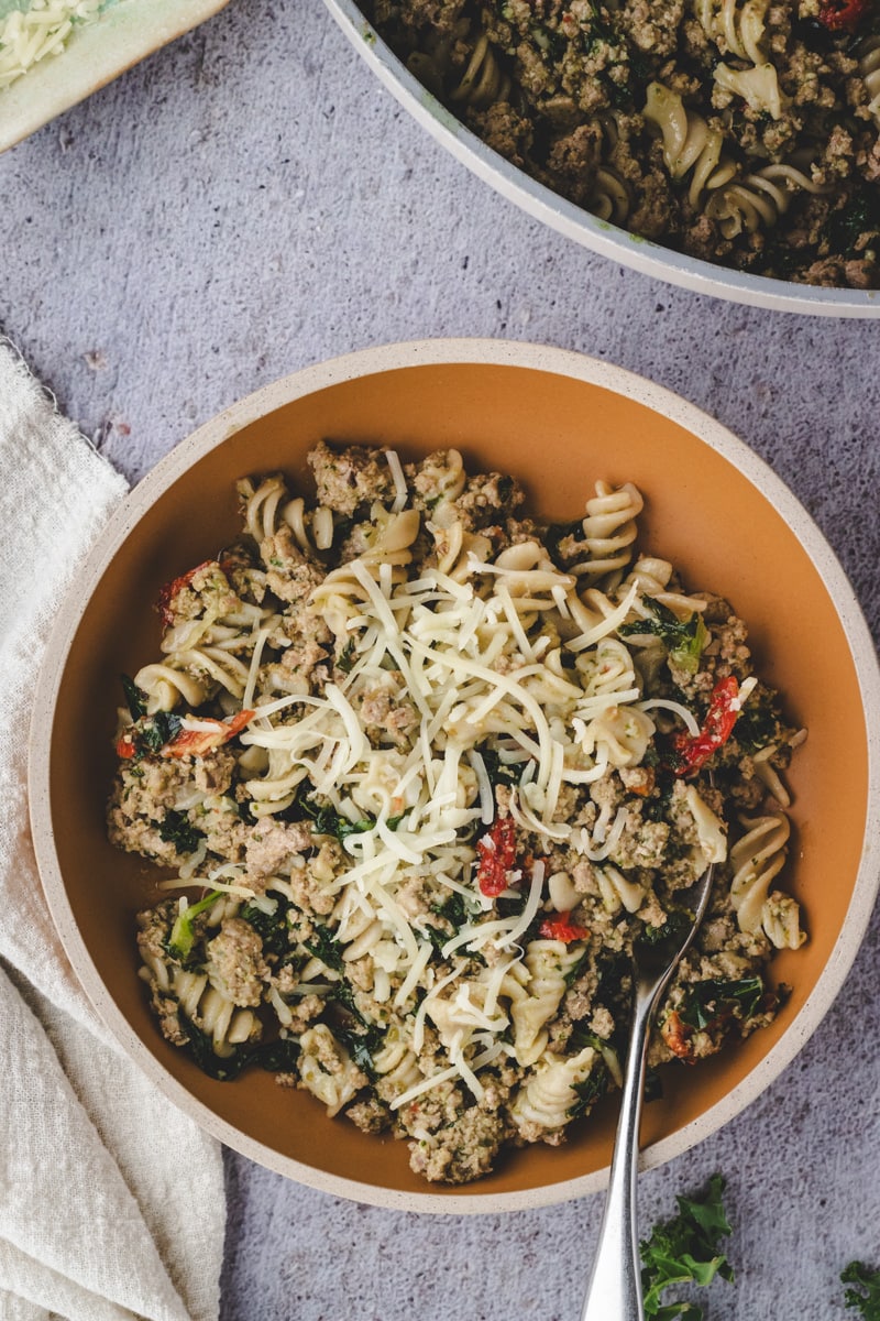 Best Ground Turkey Pesto Pasta with Kale in a bowl with a fork and napkin.