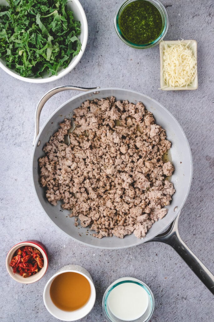Cooking ground turkey in a large skillet.