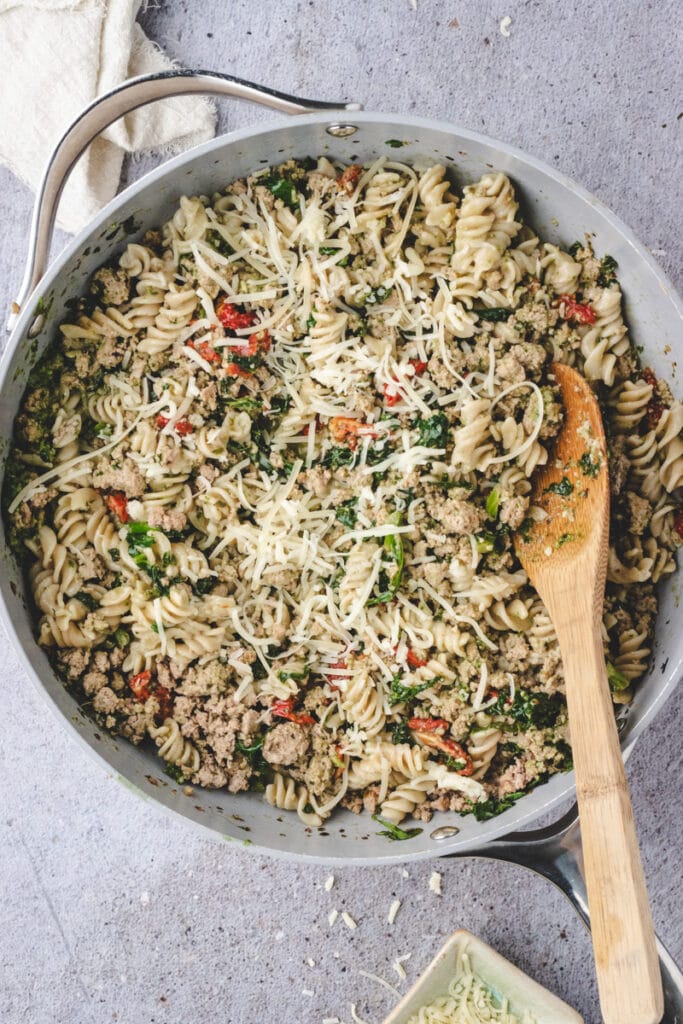 Ground turkey milk and chicken broth, sun dried tomatoes and pesto in a large pan with pasta.
