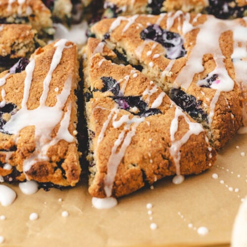 Close up of scone wedge with blueberries and glaze.