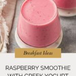 Two glasses filled with refreshing raspberry smoothie with Greek yogurt sit on white saucers; a beige textured cloth lies beside them. Text below reads: Breakfast Ideas: Raspberry Smoothie with Greek Yogurt.