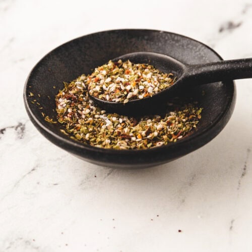 homemade za'atar spice in a small spice bowl with a spoon.