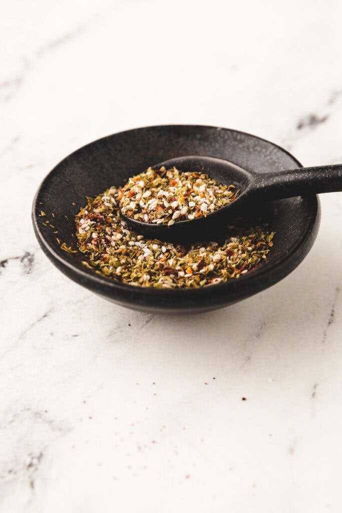 homemade za'atar spice in a small spice bowl with a spoon.