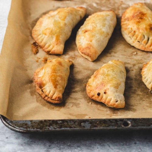Apple empanadas on a sheet pan.
