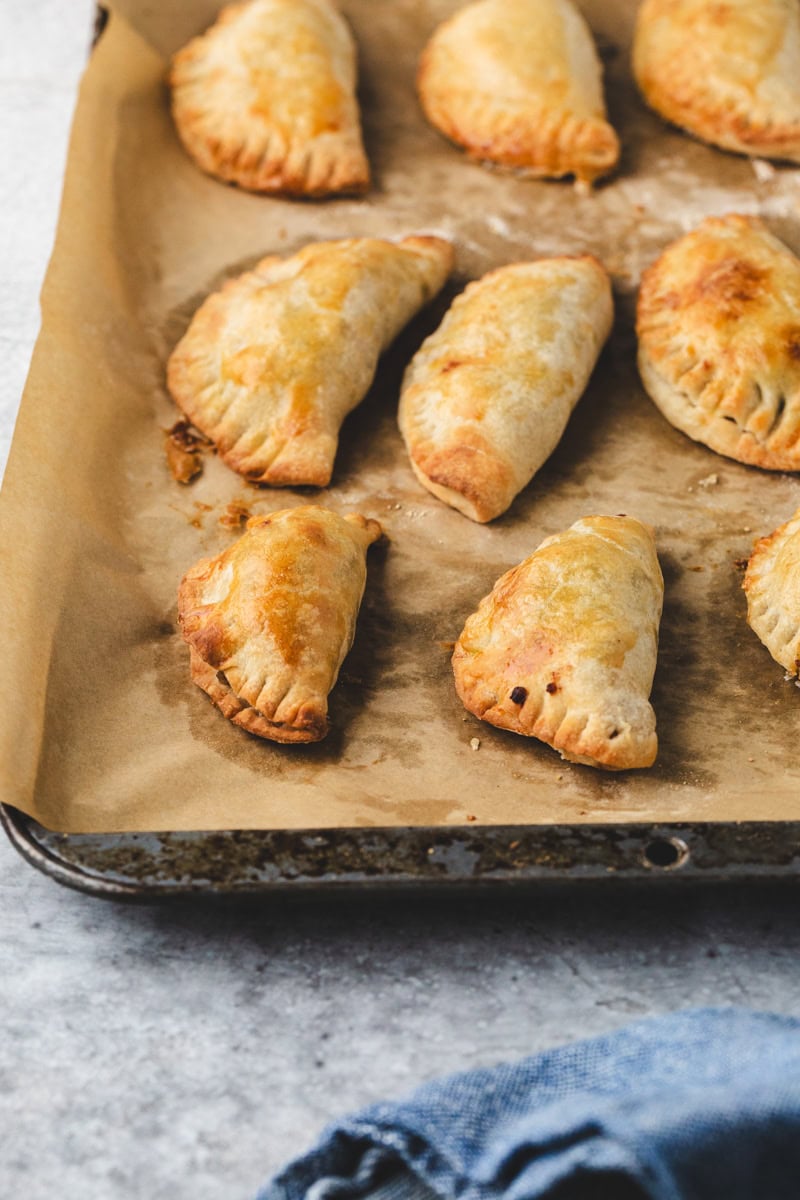 Apple empanadas on a sheet pan.