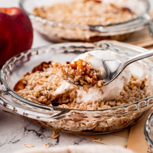 close up bite of peach crisp and vanilla ice cream