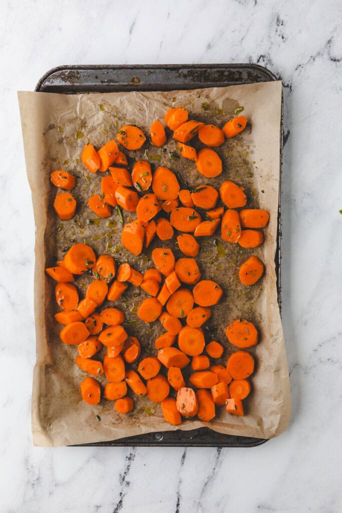 adding rosemary and salt and pepper to carrots.