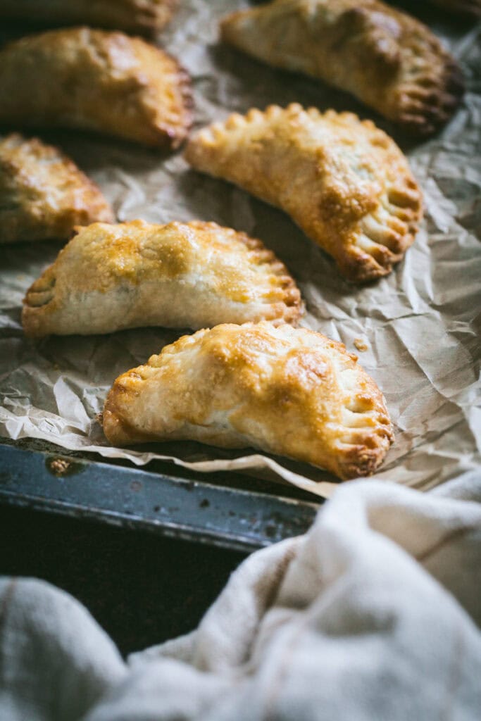 fresh baked empanadas on a sheet pan.