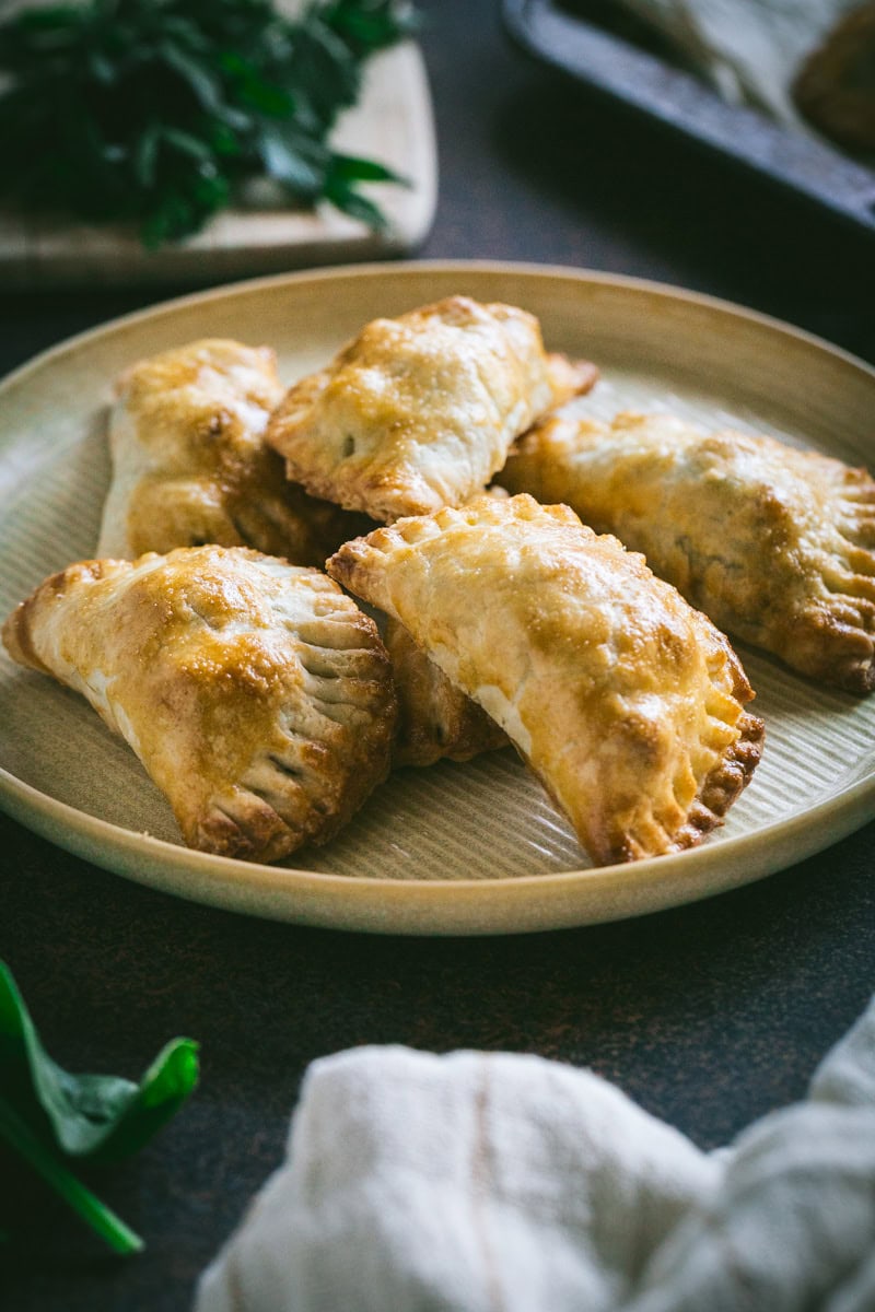 spinach feta empanada with groun chicken on a plate.