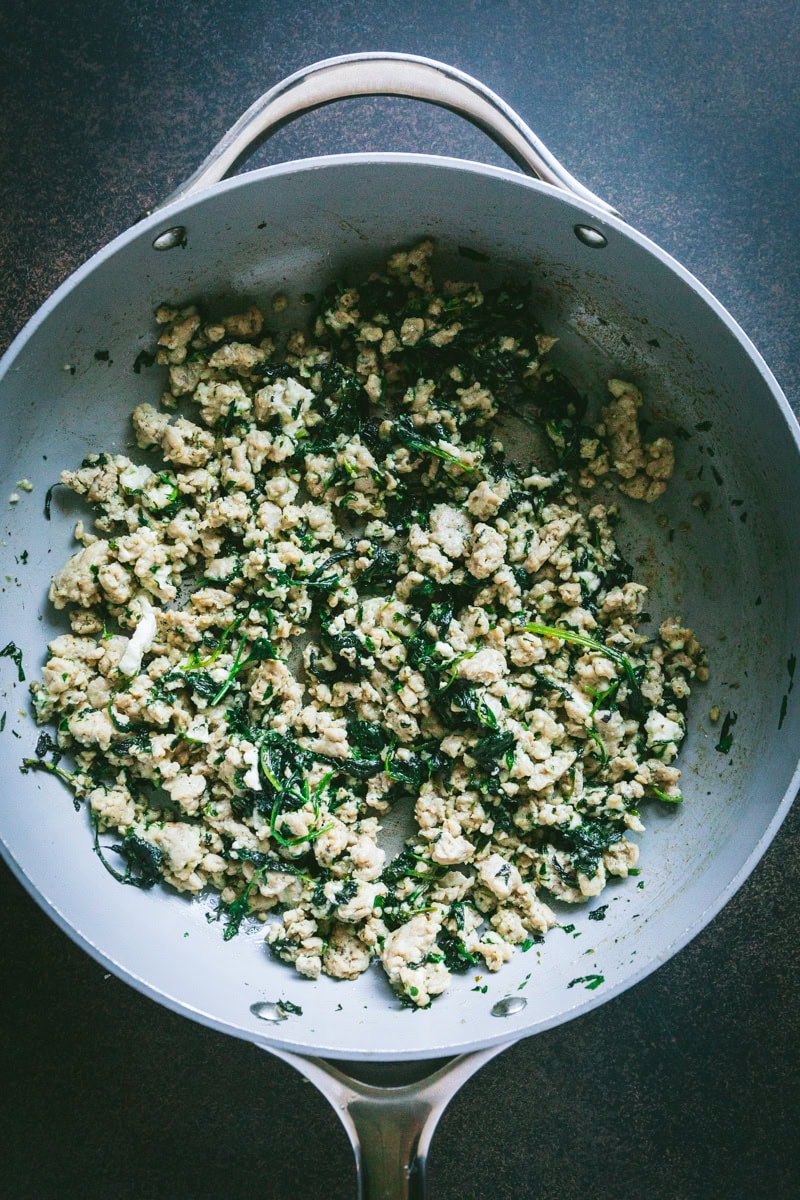 ground chicken with spinach in a large pan.