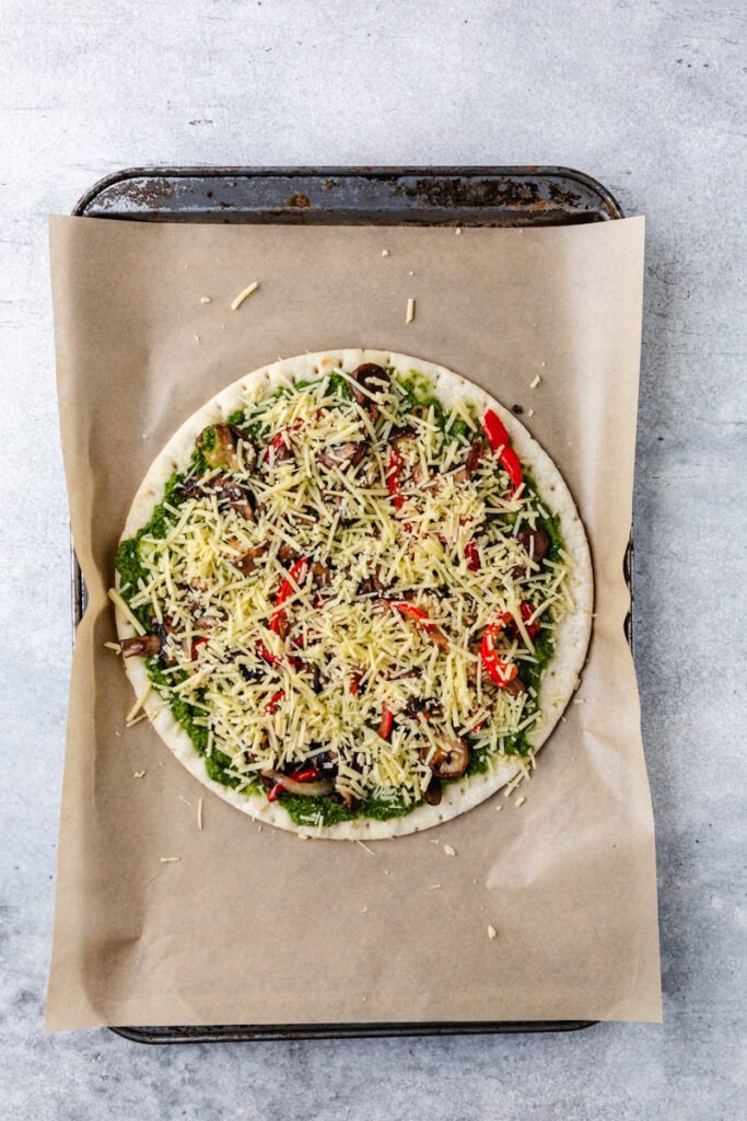 adding cheese to pizza.