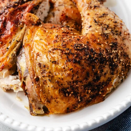 close up pic of roasted chicken thigh on a platter.