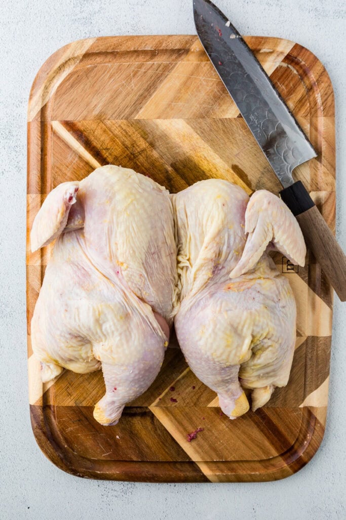 spatch cocked chicken on a cutting board. 