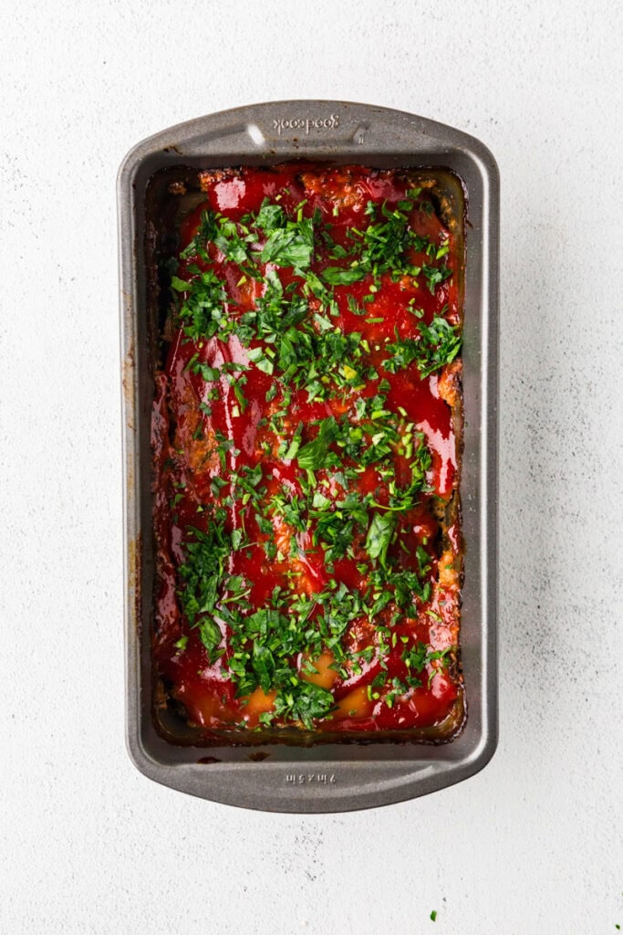 gluten free turkey meatloaf with ketchup and parsley on top.
