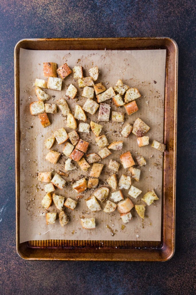 croutons on a baking sheet with spice and oil.
