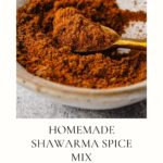 A bowl brimming with a homemade shawarma spice recipe, a spoon perched on the edge. Text below reads Homemade Shawarma Spice Mix and Easy and Healthy. A website URL graces the bottom.