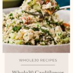 A close-up of a bowl filled with Cauliflower Tabbouleh. A spoon holds a portion above the bowl, showcasing finely chopped vegetables and fresh herbs. Text reads Whole30 Cauliflower Tabbouleh.