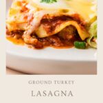 A close-up of Ground Turkey Lasagna on a white plate, topped with melted cheese and tomato sauce, garnished with herbs. Text below reads Ground Turkey Lasagna, Healthy Comfort Food.