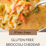 A spoonful of creamy gluten free broccoli cheddar soup with carrots and broccoli florets, held above a bowl of soup. Text overlay reads: Winter Soups. Gluten Free Broccoli Cheddar Soup. whensaltyandsweetunite.com.