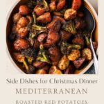 A bowl of roasted red potatoes and broccoli, seasoned with herbs, sits on a table. Text below reads: Side Dishes for Christmas Dinner, Mediterranean, roasted red potatoes and broccoli.