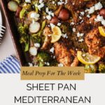 A sheet pan filled with baked Mediterranean chicken, roasted vegetables, lemon slices, and crumbled feta cheese. Below, text reads: Meal Prep For The Week—Sheet Pan Mediterranean Chicken with a website link.