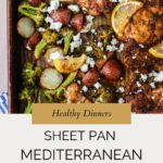 A sheet pan filled with roasted chicken thighs, sliced potatoes, broccoli, lemon slices, and crumbled feta cheese. Text overlay reads: Healthy Dinners - Sheet Pan Mediterranean Chicken.