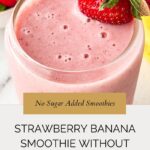 A glass of creamy pink strawberry banana smoothie without yogurt, garnished with a whole strawberry. Text overlay reads: No Sugar Added Smoothies. Strawberry Banana Smoothie Without Yogurt. whensaltyandsweetunite.com.