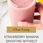 A hand holds a glass of strawberry banana smoothie without yogurt, topped with a fresh strawberry. Text reads: Clean Eating. Strawberry Banana Smoothie Without Yogurt. Whensaltyandsweetunite.com.