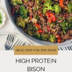 A skillet of bison stir fry with ground bison, broccoli, red bell peppers, and onions sits beside a white plate and forks. Text reads: “High Protein Bison Stir Fry, Meal Prep for the Week.”.