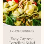 A close-up of a Caprese Tortellini Pasta Salad featuring cheese tortellini, cherry tomatoes, fresh spinach, mozzarella balls, walnuts, and basil in a bowl. Text reads Easy Caprese Tortellini Salad – Summer Dinners.